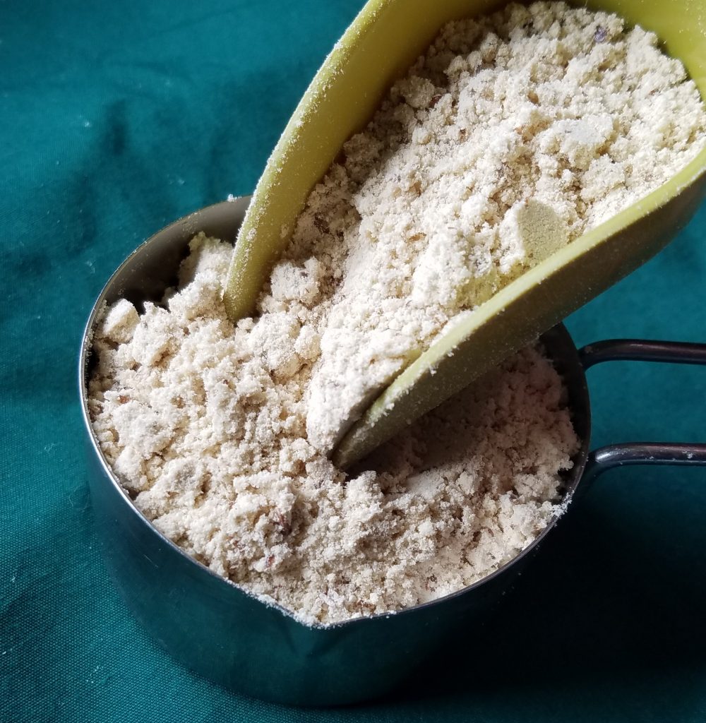 low carb baking mix being scooped into a measuring cup.