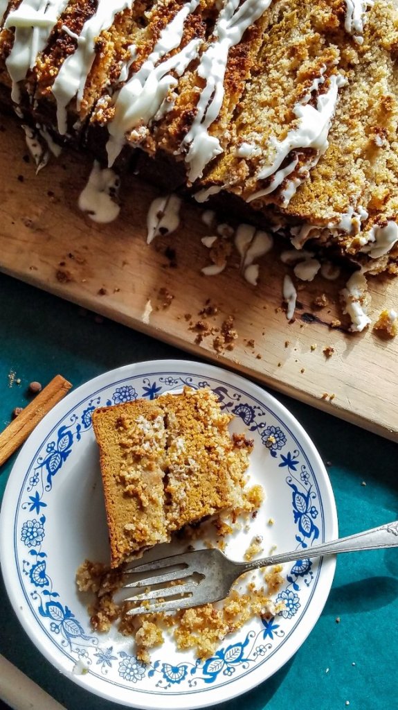 keto pumpkin bread on a cutting board with a piece on a plate