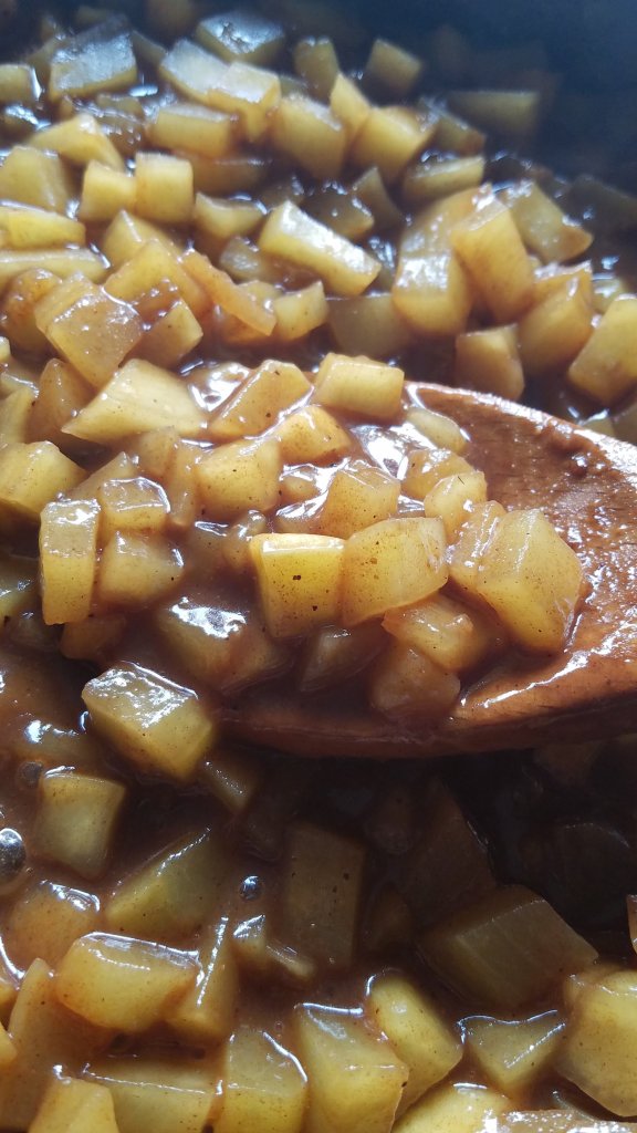 keto apple pie filling in a skillet with a wooden spoon