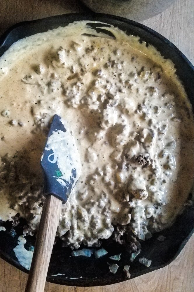 tatertot casserole filling in skillet before baking.