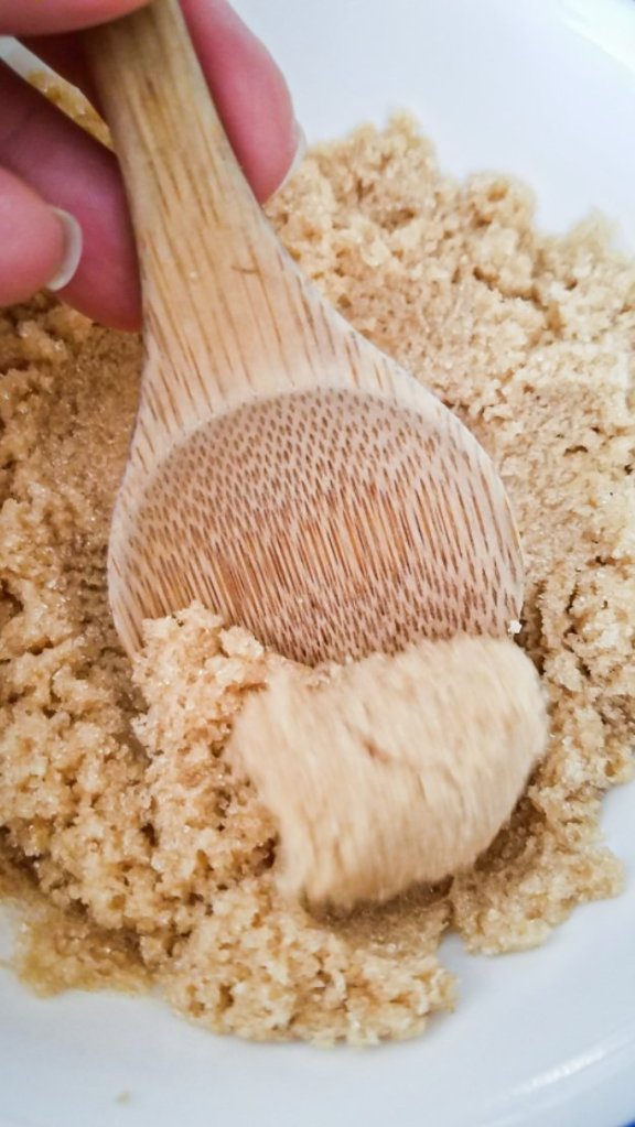 brown sugar in a bowl being scooped up with a spoon