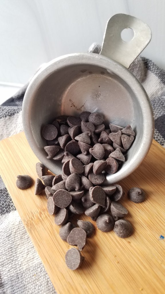 keto banana chocolate chip pudding cookies chocolate chips spilling out of a measuring cup