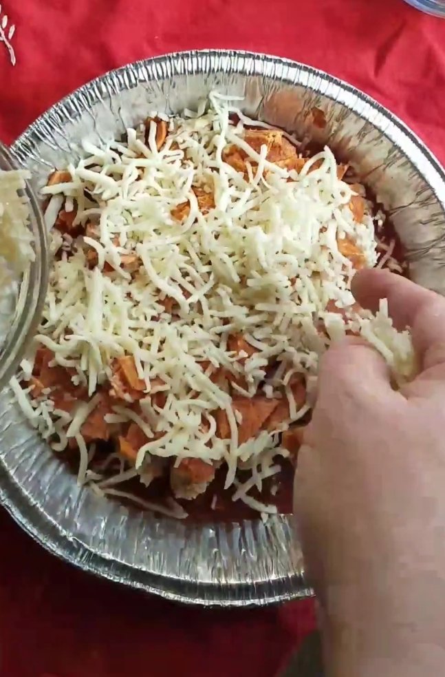 sprinkling cheese on easy low carb keto crustless pizza casserole recipe