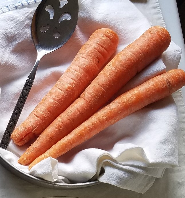 fresh carrots in a pan with a cake server