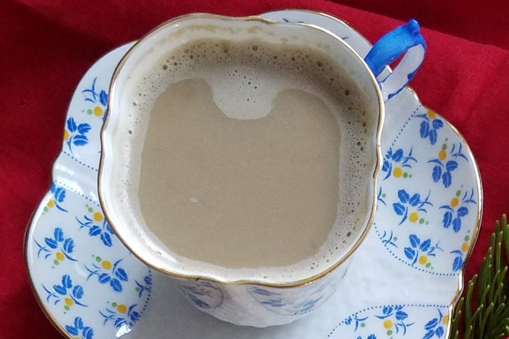 warm chai tea latte in a small cup with saucer