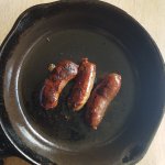 breakfast sausage links cooked in a small cast iron skilet