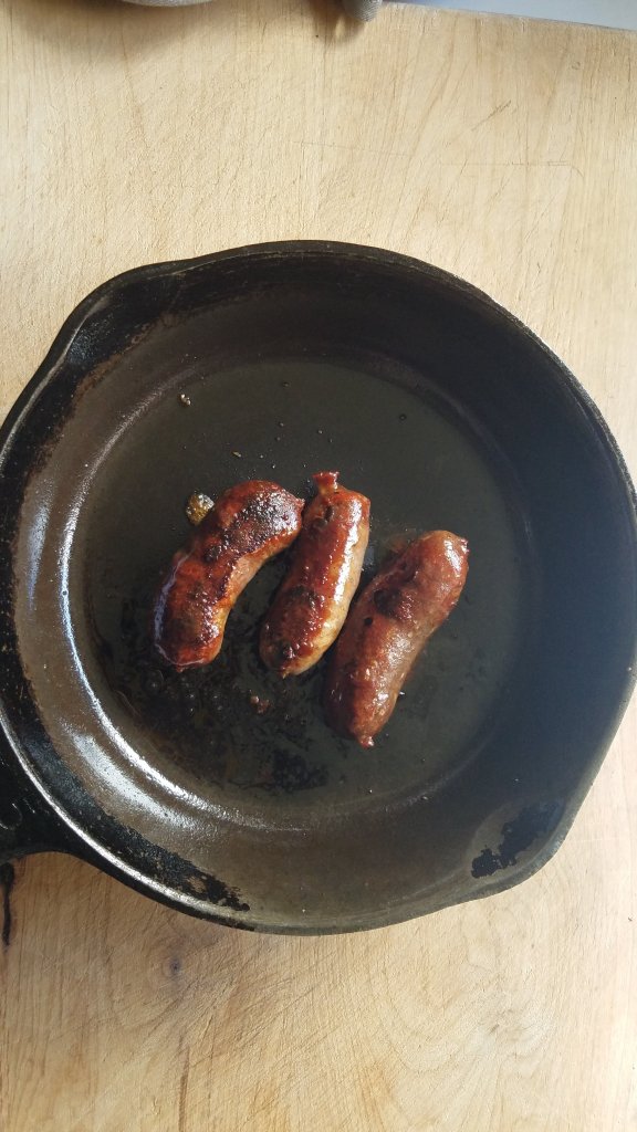 breakfast sausage links cooked in a small cast iron skilet