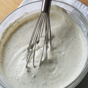 Copycat Longhorn Steakhouse Ranch Dressing Recipe in a bowl with a whisk