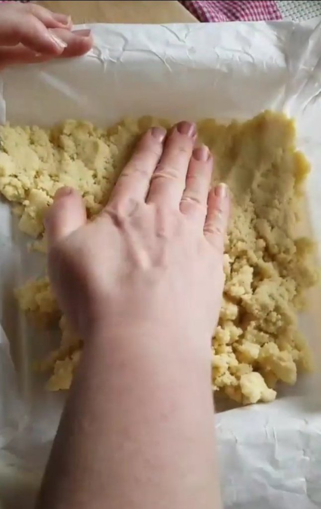 pressing almond crust into pan.