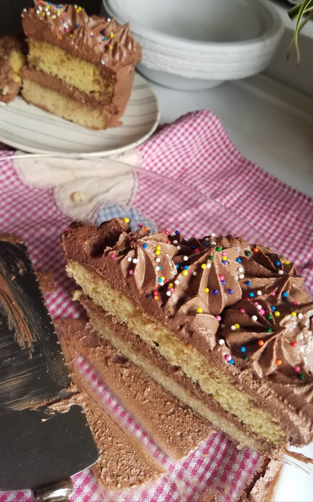 a slice of Sugar Free Keto Vanilla Cake frosted with chocolate frosting