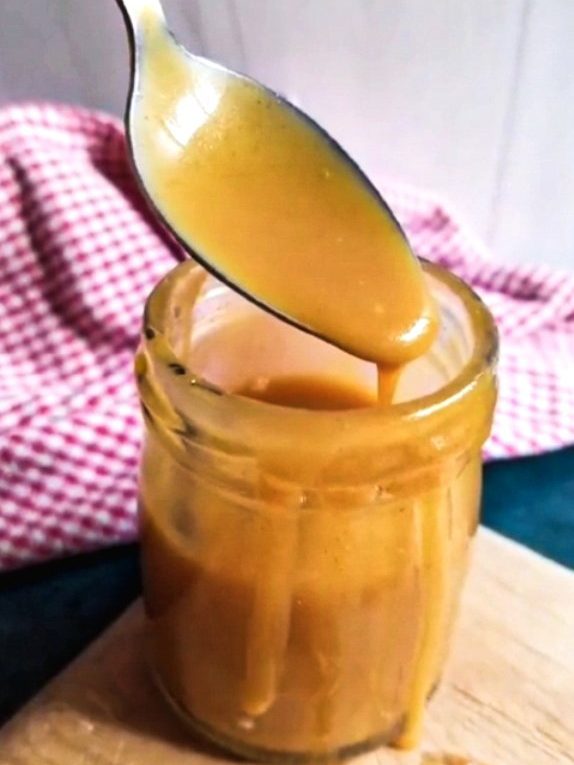caramel dripping from a spoon into a jar