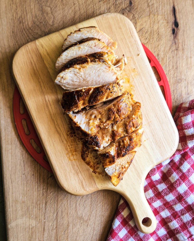seasoned cast iron skillet chicken breasts cut on a cutting board