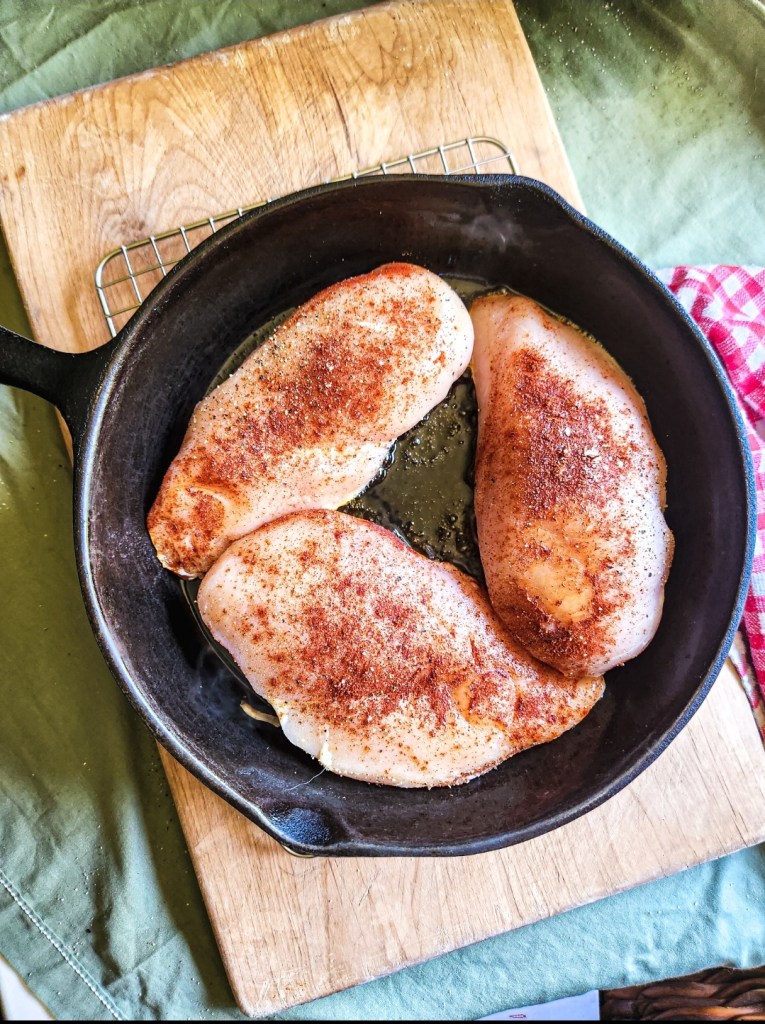 seasoned chicken breast in a cast iron skillet