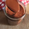 homemade low carb gluten free chocolate syrup in a jar dipped from a spoon