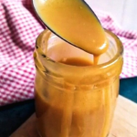 keto caramel sauce dripping from a spoon into a jar