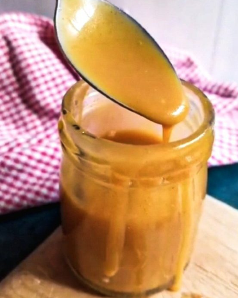 keto caramel sauce dripping from a spoon into a jar
