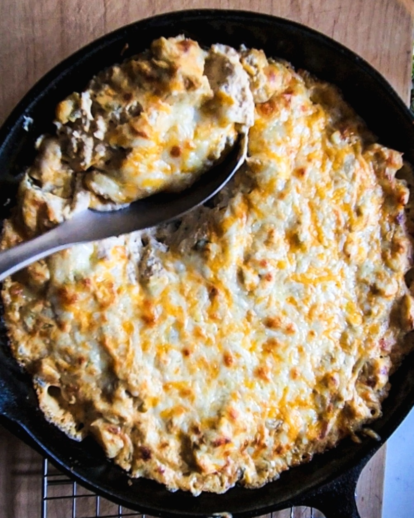 gluten free cheesy green chile chicken skillet recipe done and being served up with a spoon