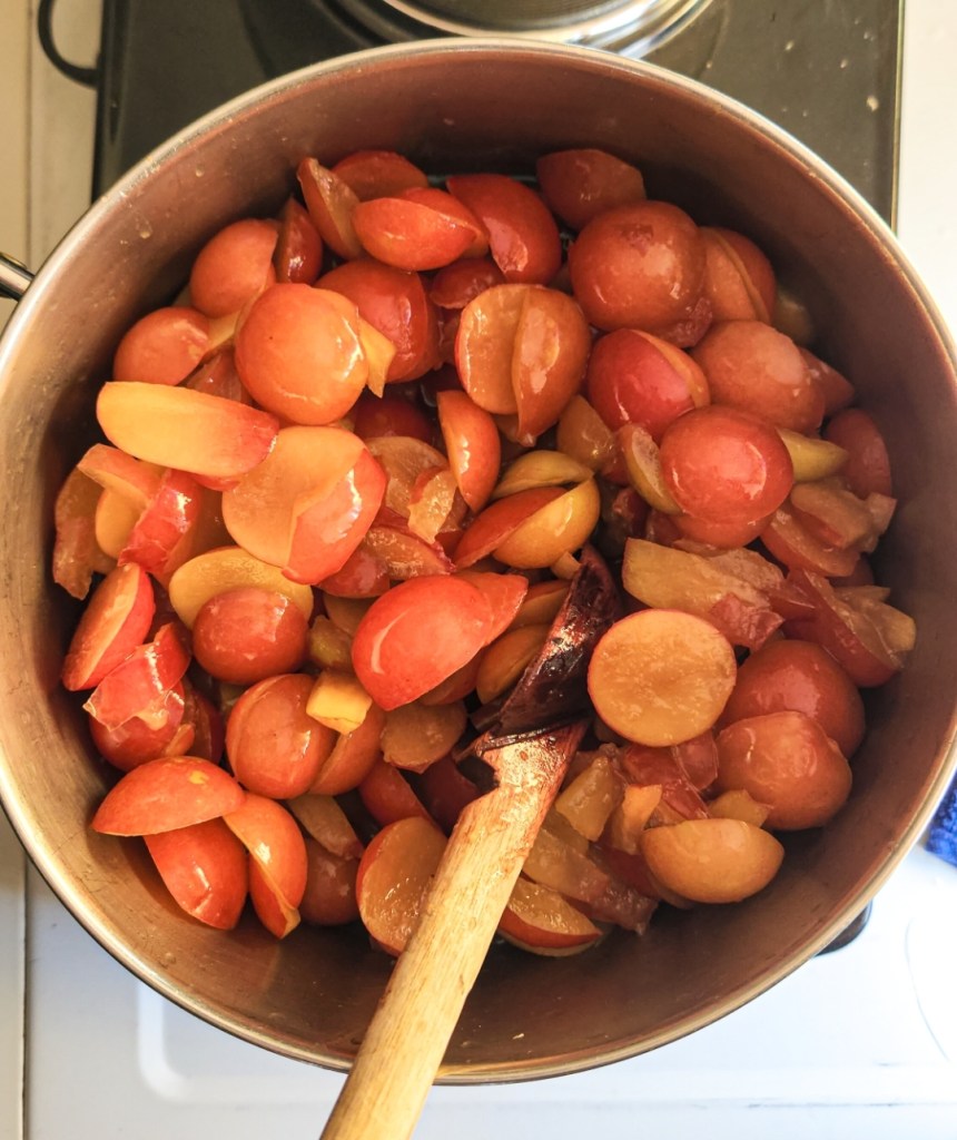 Folding plums into sugar syrup