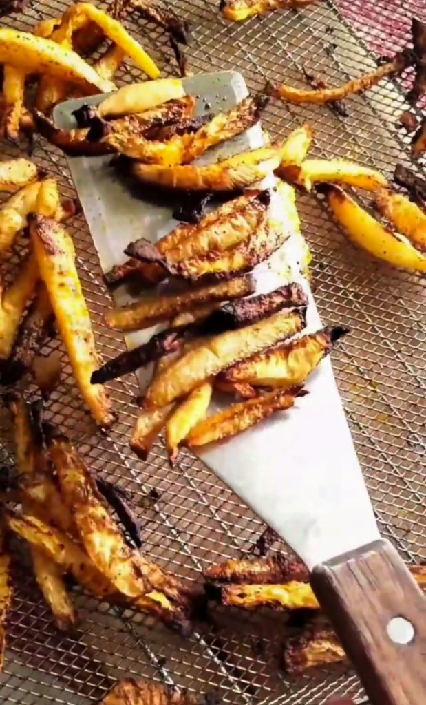 Air fried Kohlrabi sticks with a spatula