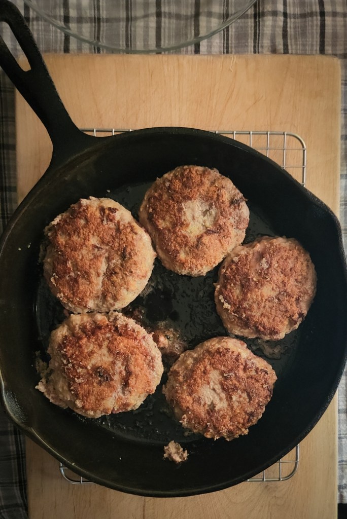 Gluten free Salisbury steak meat patties browned in a cast iron skillet
