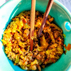 pork fried rice with cauliflower rice in a bowl with chopsticks