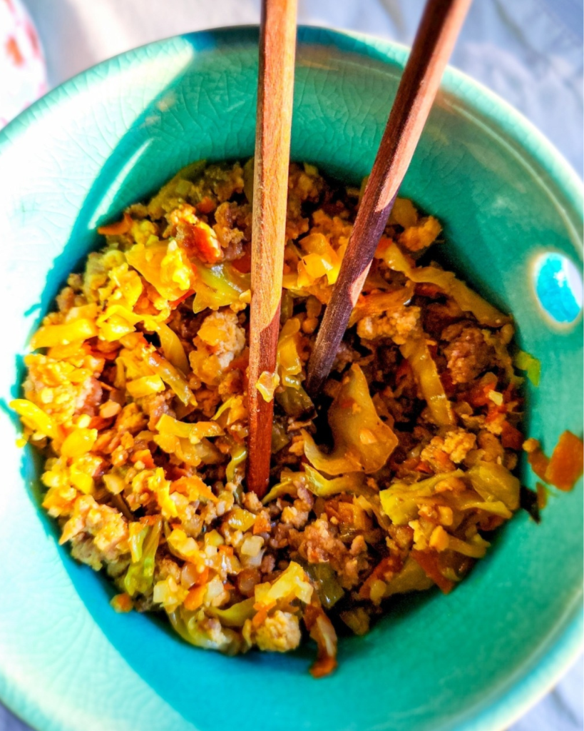 pork fried rice with cauliflower rice in a bowl with chopsticks