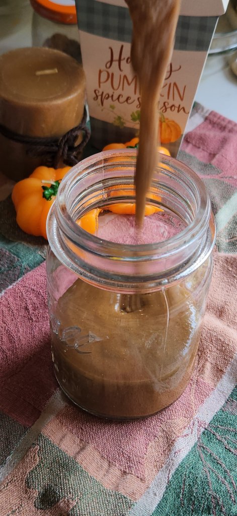 pouring pumpkin spice sauce in a jar to save.