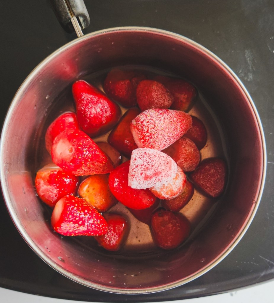 strawberries in a saucepan to make sauce.