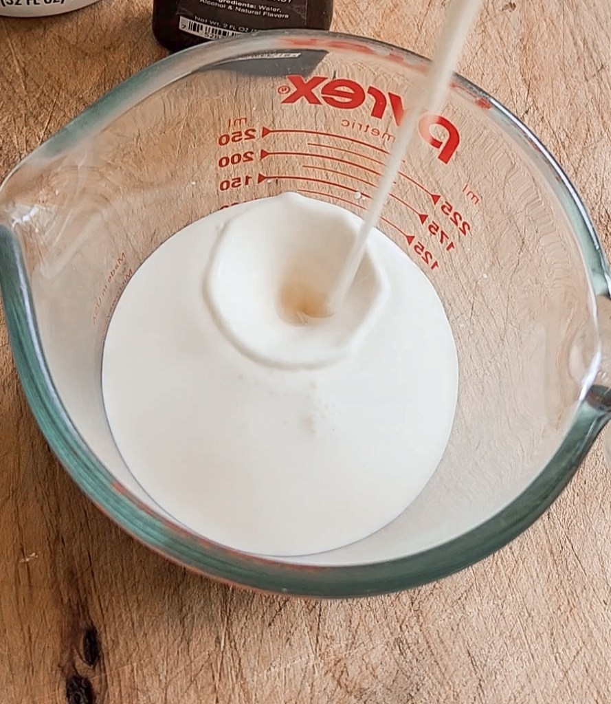 Pouring in unsweetened milk to create homemade coffee creamer.