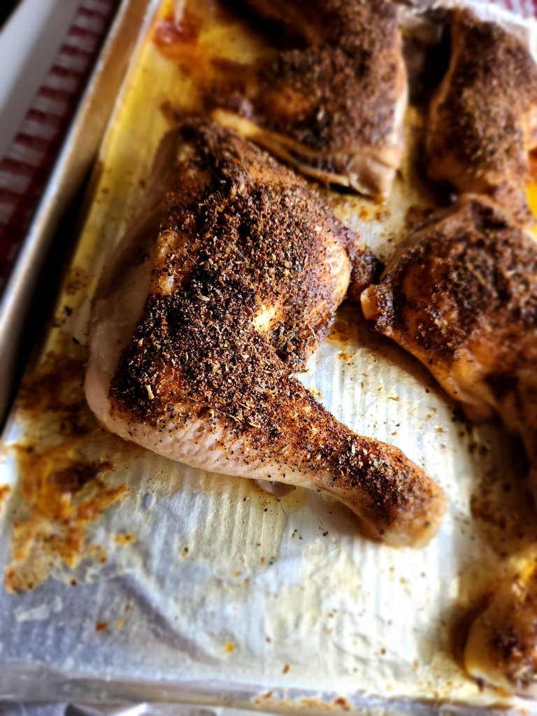 The best roasted chicken leg quarters on a baking sheet