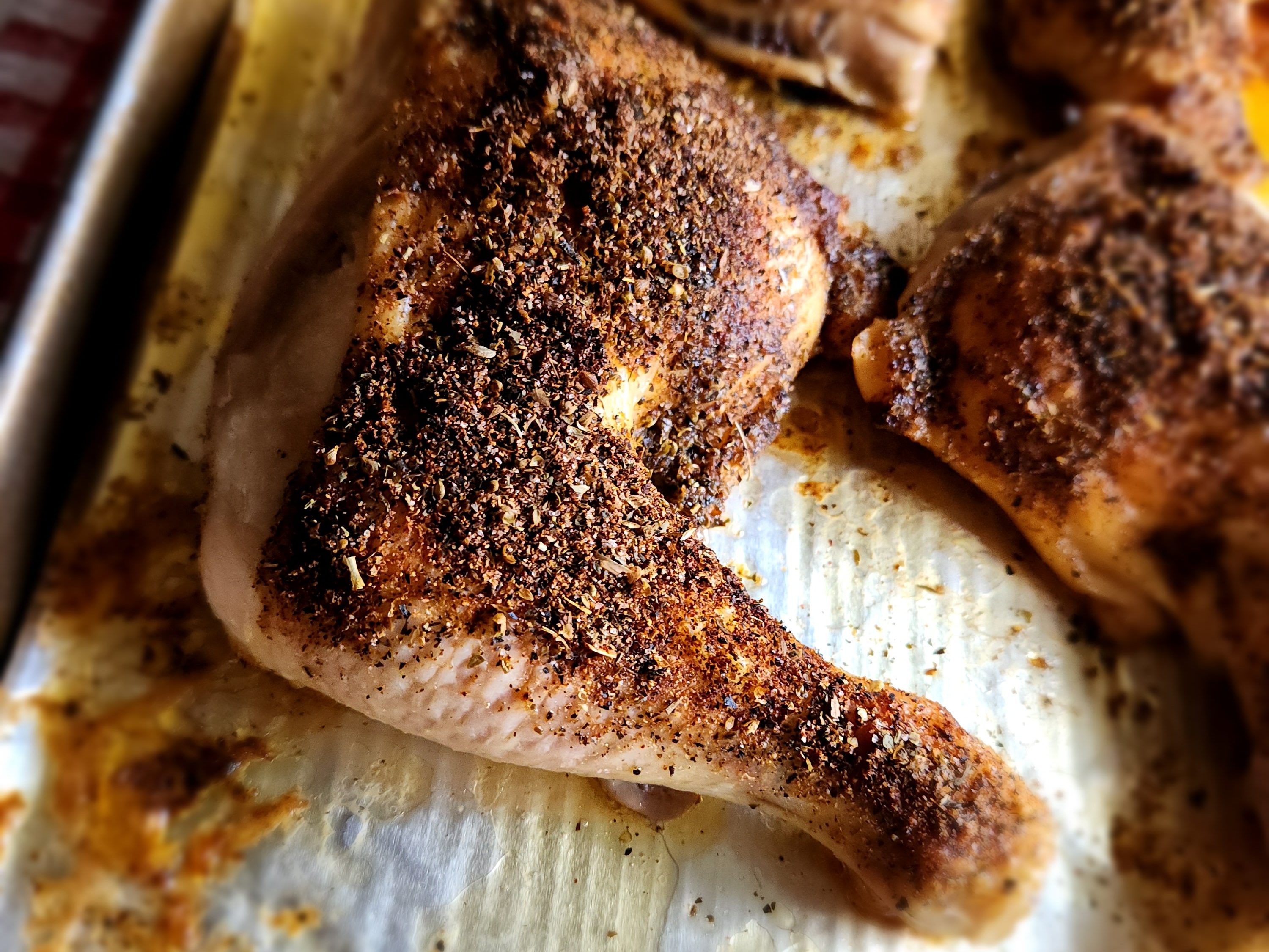 The best roasted chicken leg quarters on a baking sheet