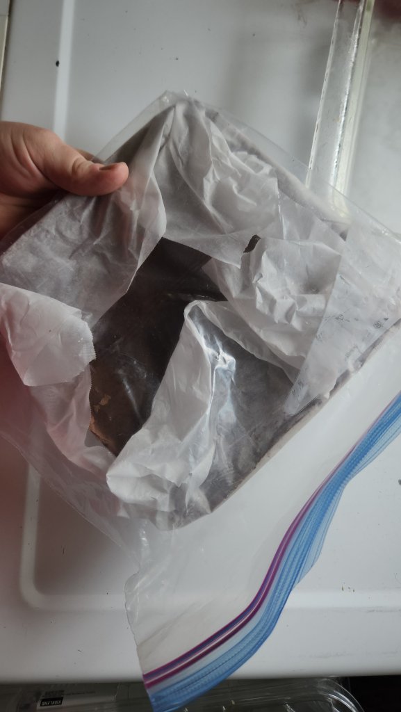 frozen brownie batter being put into a freezer bag.