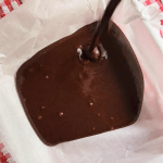 Homemade Brownie Batter being poured into a parchment lined pan before freezing