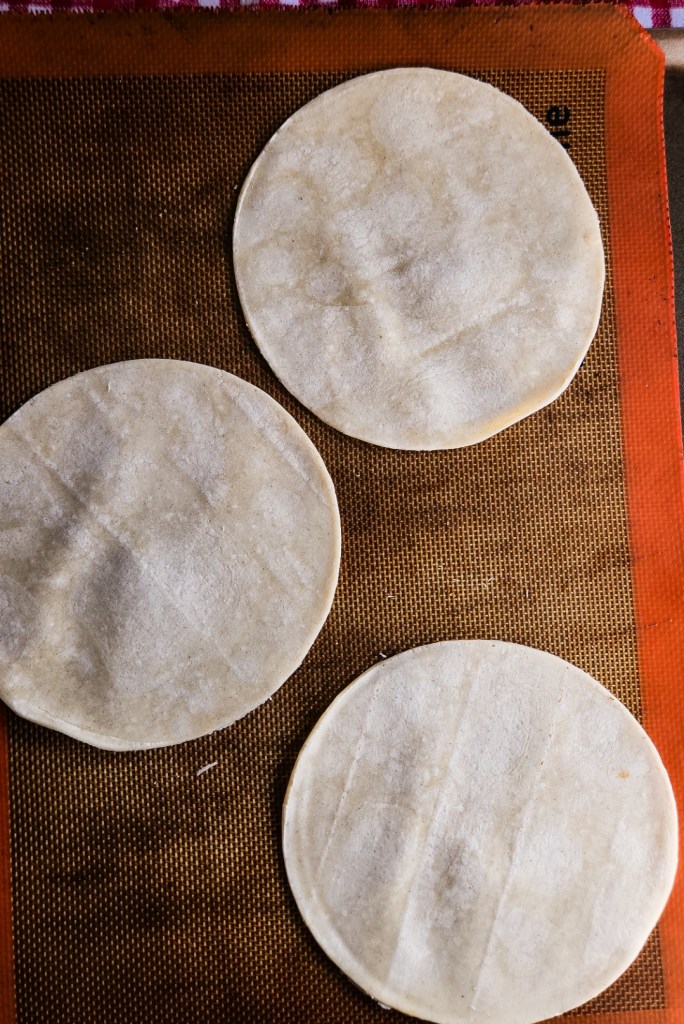 low carb tortillas laid on a silpat lined pan.