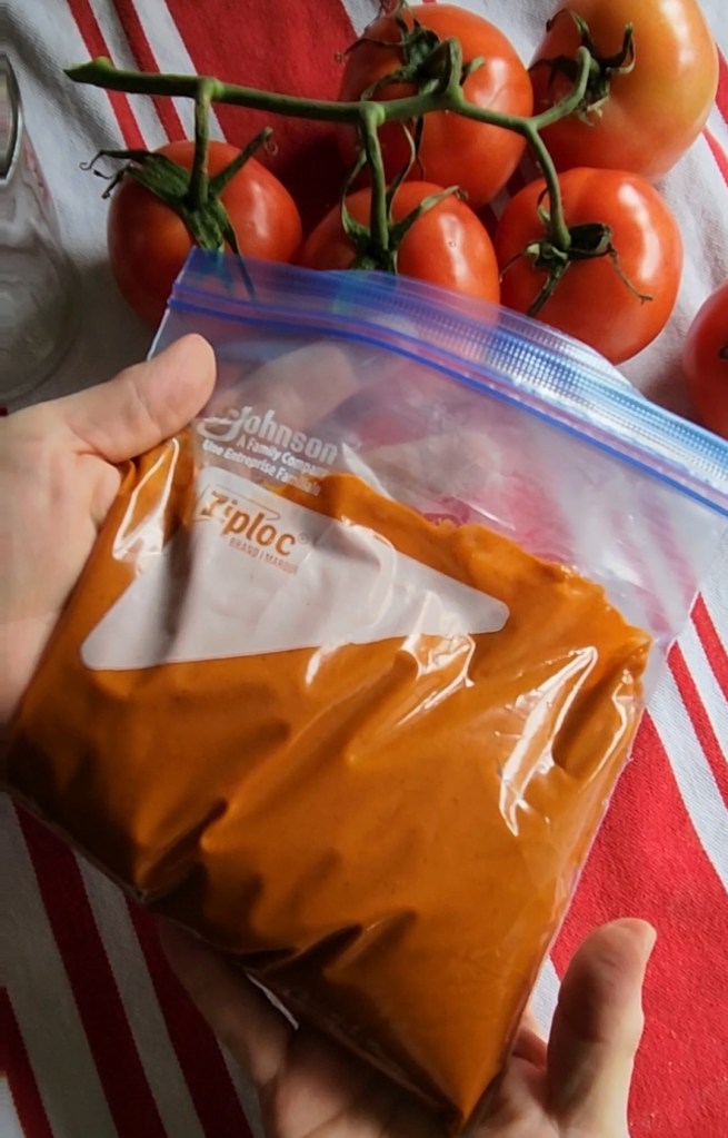 Low carb gluten-free enchilada sauce in a Ziploc bag ready for the freezer.