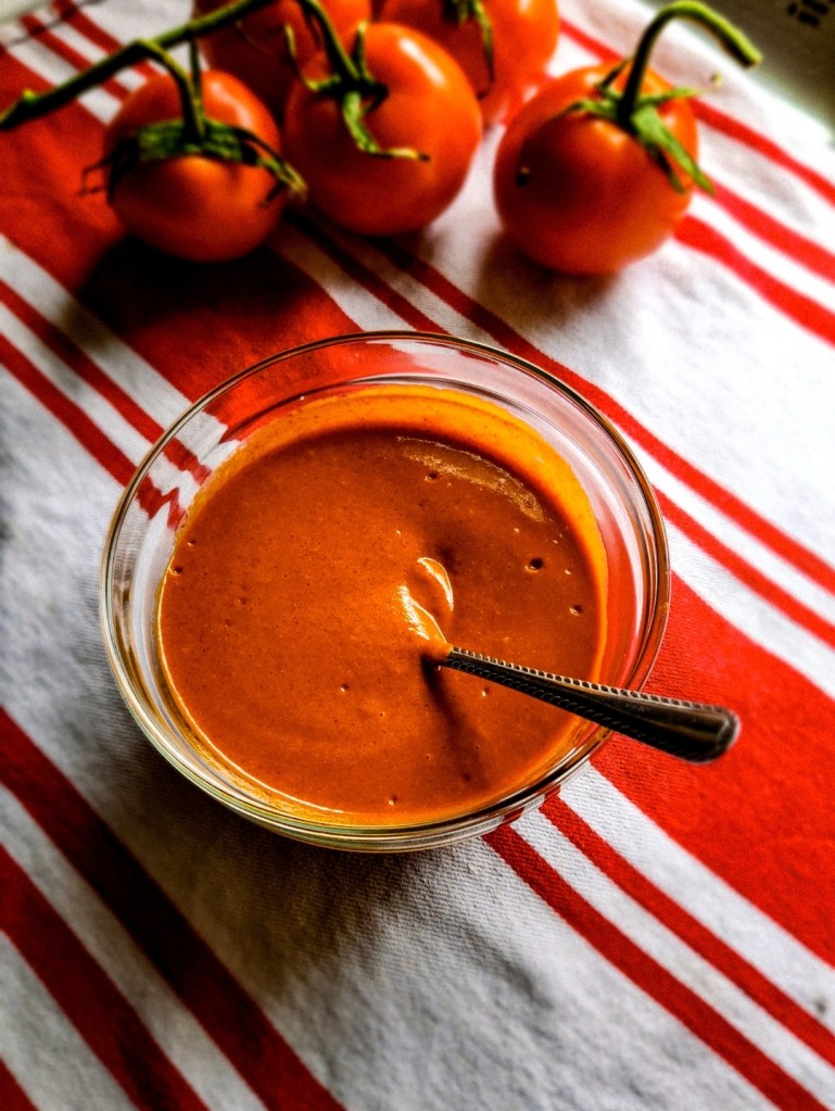 Easy low carb gluten-free recipe for enchilada sauce completed and in a bowl with a spoon.