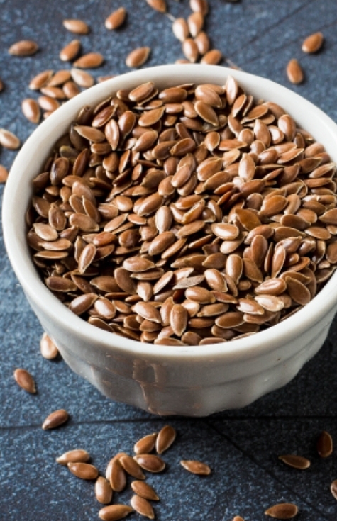Whole flaxseed in a small white bowl.