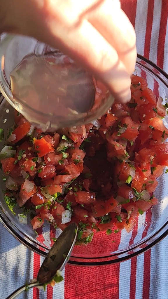 pouring lime juice all over the chopped veggies for the pico de gallo.