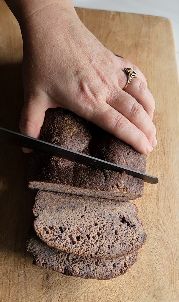 cutting the best gluten free low carb bread on a cutting board.