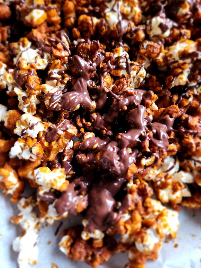 Low carb caramel popcorn made without corn syrup and drizzled with melted sugar-free chocolate.