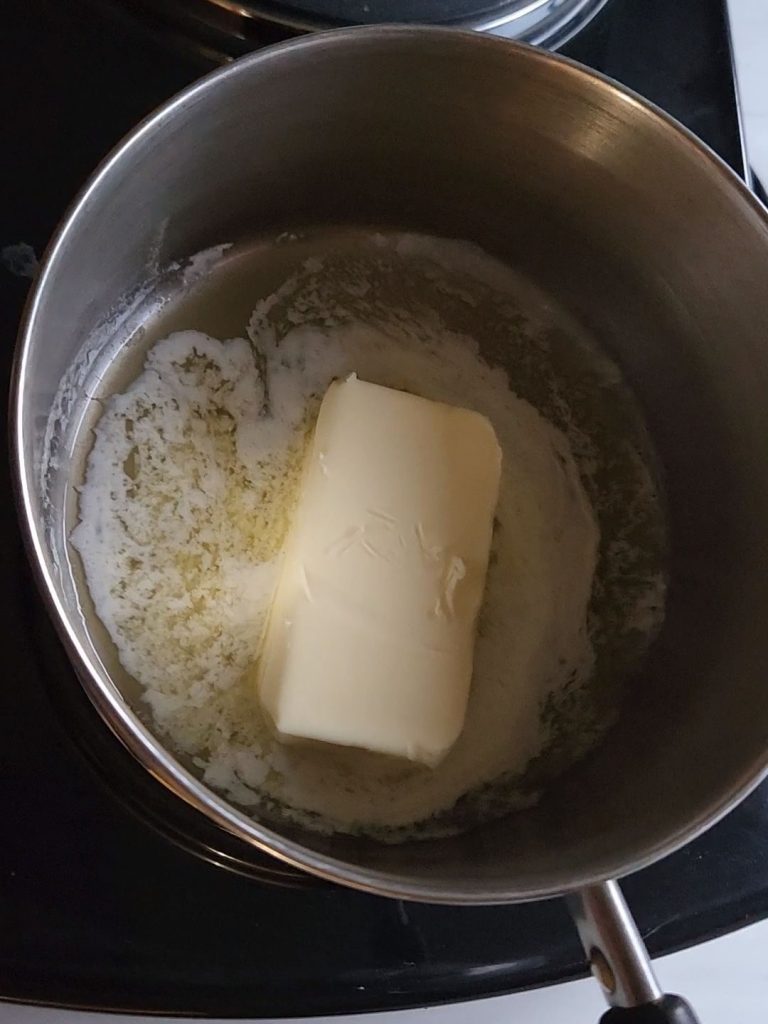 Melting butter in a saucepan to make caramel sauce.