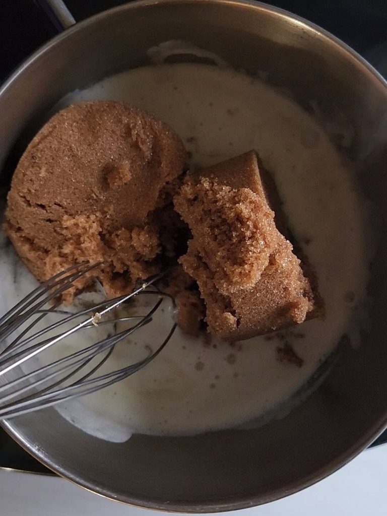 Mixing in sugar-free brown sugar into melted butter to make caramel sauce.