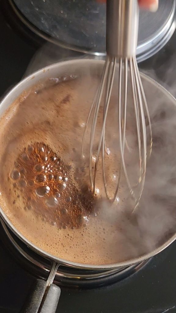 Bringing Kita brown sugar and water to a boil in a saucepan.