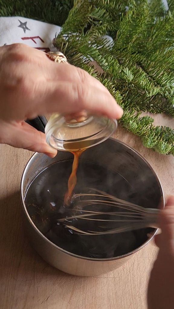 Adding vanilla extract to the gingerbread syrup and the saucepan.
