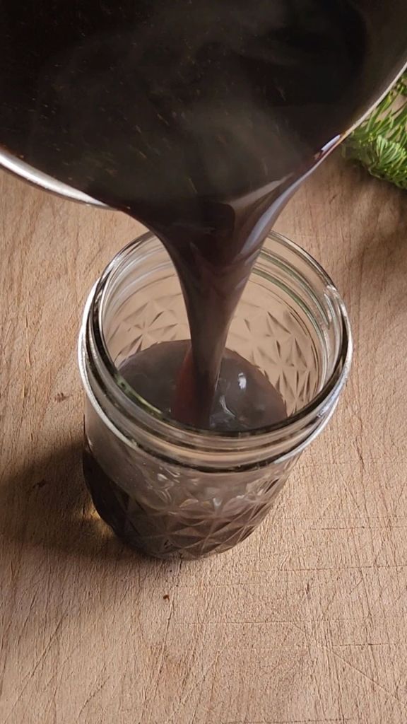 Pouring low-carb gingerbread syrup into a jar.