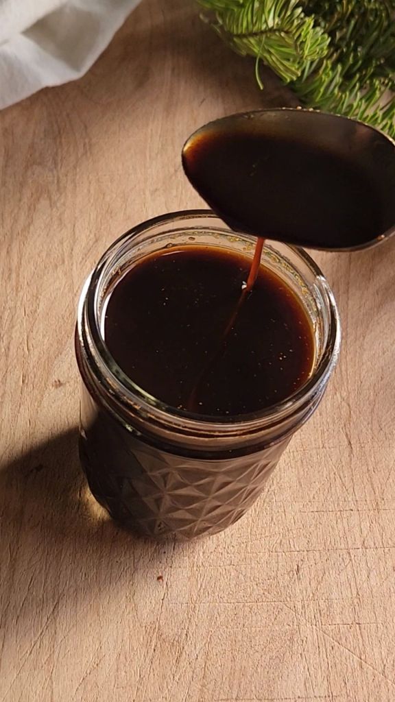 Pouring low carb gingerbread syrup into a small jar.