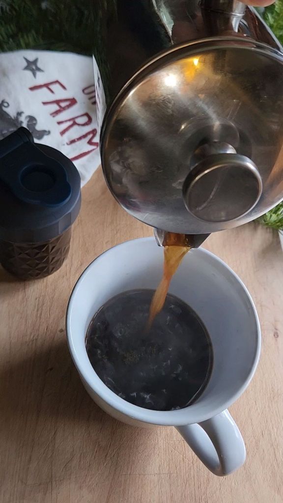 Pouring coffee into mug after measuring gingerbread syrup into the mug for a latte.