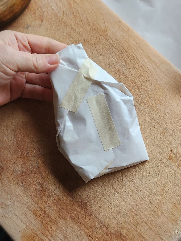 A slice of cooked pork loin wrapped in freezer paper.