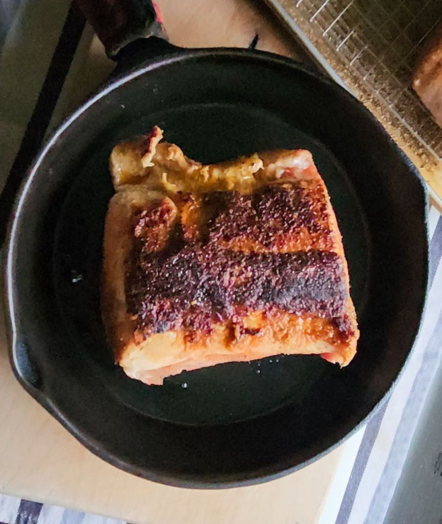 Pork loin with a dry spice rub seared in a skillet.