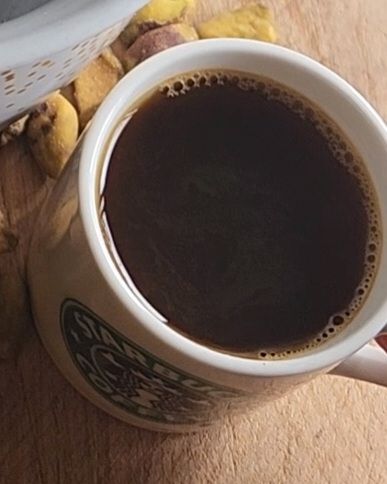 Coffee in a small Starbucks coffee mug.